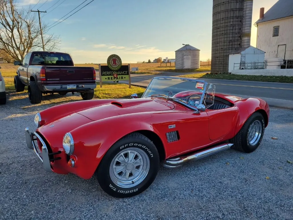 A red classic Cobra parked outside the Diligence Automotive shop